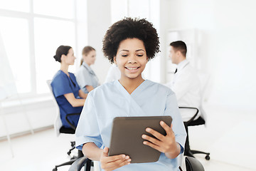 Image showing happy nurse with tablet pc over team at hospital