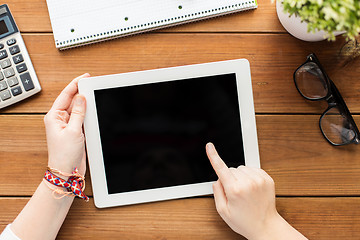 Image showing close up of woman with tablet pc on wooden table