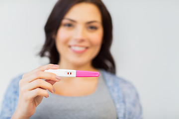 Image showing close up of happy woman with home pregnancy test