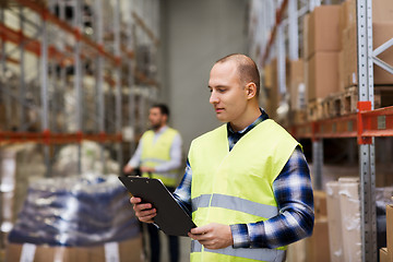 Image showing man with clipboard in safety vest at warehouse