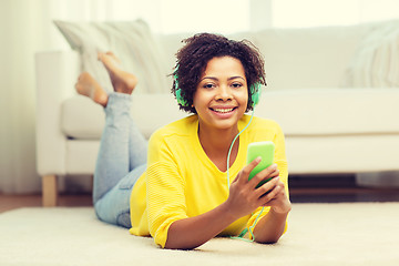 Image showing happy african woman with smartphone and headphones