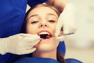 Image showing female dentist checking patient girl teeth