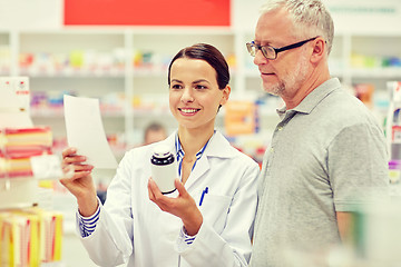 Image showing pharmacist and senior man buying drug at pharmacy