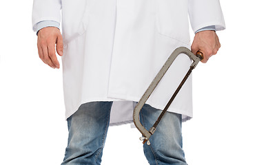 Image showing Crazy doctor is holding a big saw in his hands