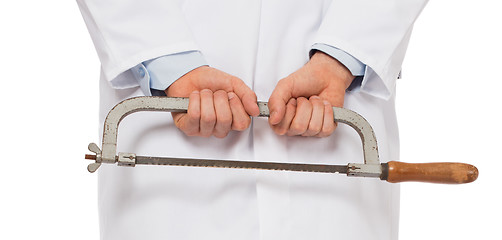 Image showing Crazy doctor is holding a big saw in his hands