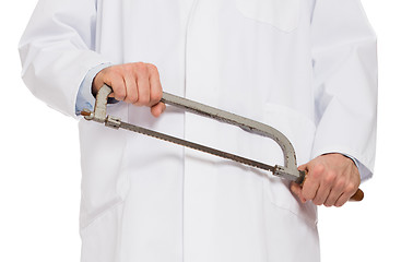 Image showing Crazy doctor is holding a big saw in his hands