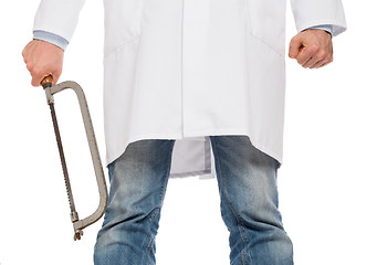 Image showing Crazy doctor is holding a big saw in his hands