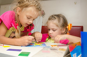 Image showing Two girls on the train sitting at the table on the lower second-class place car and enthusiasm make applique