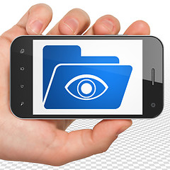 Image showing Finance concept: Hand Holding Smartphone with Folder With Eye on display