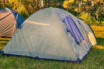 Image showing Private camping tent on the meadow near the river.