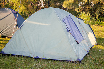 Image showing Private camping tent on the meadow near the river.