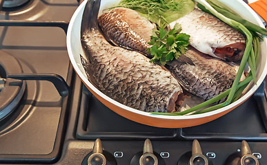 Image showing Fish and components for her preparation in a large skillet.