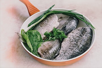 Image showing Fish and components for her preparation in a large skillet.