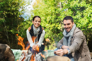 Image showing happy couple roasting marshmallow over camp fire