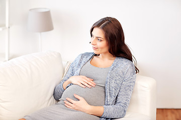 Image showing happy pregnant woman lying on sofa at home