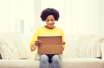 Image showing happy african young woman with parcel box at home