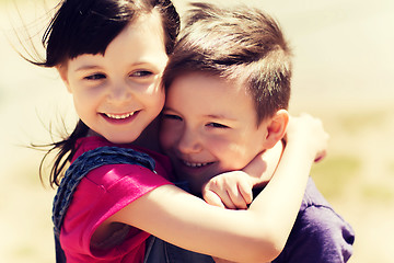 Image showing two happy kids hugging outdoors