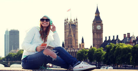 Image showing happy young woman with smartphone and headphones