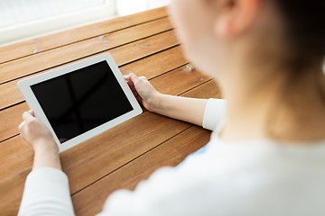 Image showing close up of woman with tablet pc on wooden table
