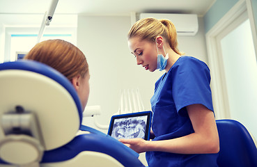 Image showing dentist showing x-ray on tablet pc to patient girl