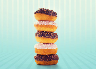 Image showing close up of glazed donuts pile over blue