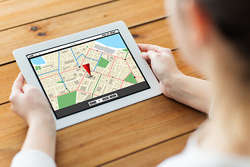 Image showing close up of woman with tablet pc on wooden table