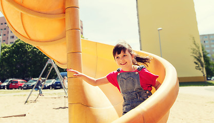 Image showing happy little girl on slide at children playground