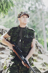 Image showing young soldier or hunter with gun in forest