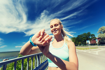 Image showing happy woman with heart rate watch and earphones