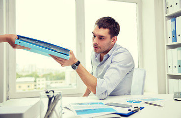 Image showing businessman taking papers from secretary in office