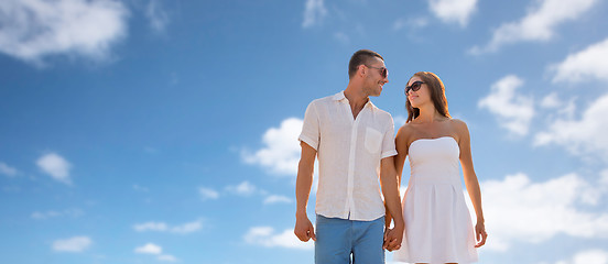 Image showing happy smiling couple walking over blue sky