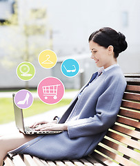 Image showing smiling business woman with laptop in city