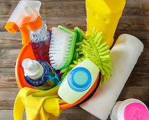 Image showing Plastic bucket with cleaning supplies on wood background