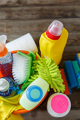 Image showing Plastic bucket with cleaning supplies on wood background