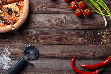 Image showing Tasty pizza with ingridients on a wooden board.