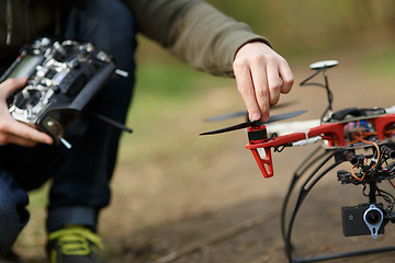 Image showing Closeup of man hand fixing propeller drone 