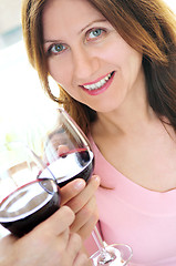 Image showing Mature woman toasting with red wine