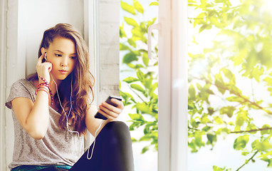 Image showing teenage girl with smartphone and earphones