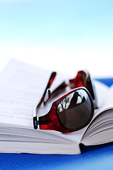 Image showing Sunglasses and book on beach chair