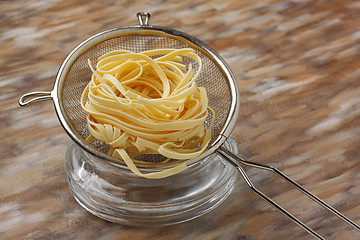 Image showing Raw noodle pasta in metal kitchen sieve