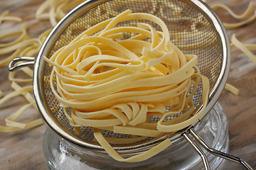 Image showing Raw noodle pasta in metal kitchen sieve