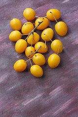 Image showing Yellow mirabelle plum fruits over painted textile background