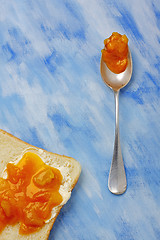 Image showing Toast slice with butter and jam and silver spoon with jam blob