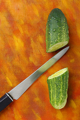 Image showing Halved cucumber and knife