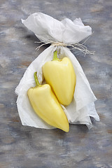Image showing Still life with two yellow peppers and white paper