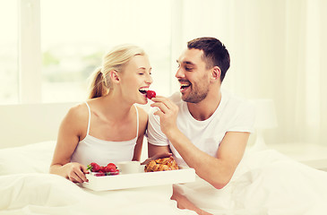 Image showing happy couple having breakfast in bed at home