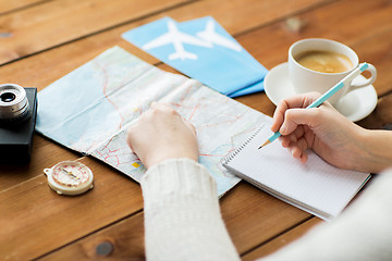 Image showing close up of traveler hands with notepad and pencil