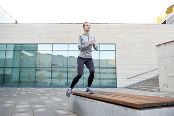 Image showing woman making step exercise on city street bench