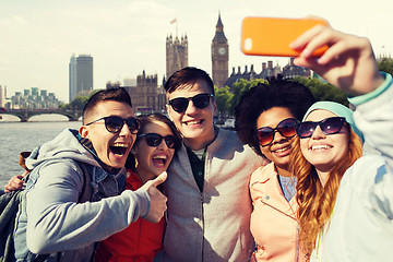 Image showing smiling friends taking selfie with smartphone