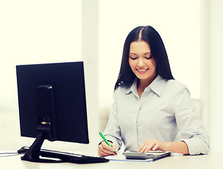 Image showing businesswoman or student working with calculator